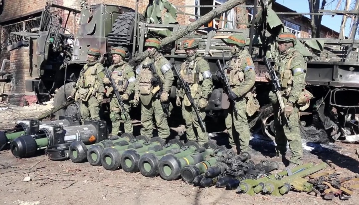 Các quân nhân Nga đứng bên cạnh các thiết bị quân sự thu giữ được gần làng Huta-Mezhyhirska, ở Ukraine.