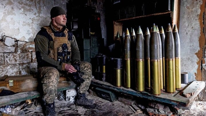 Một binh sĩ Ukraine bên số đạn pháo 155 mm.