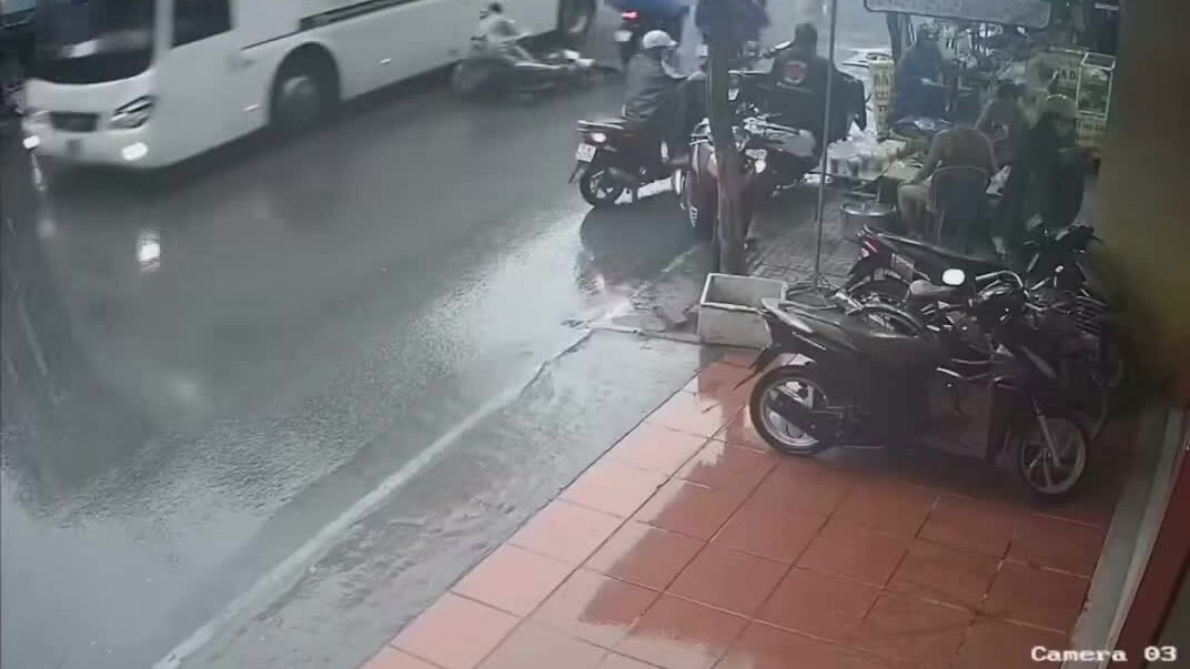 Hai người đi xe máy trượt ngã vào gầm xe khách