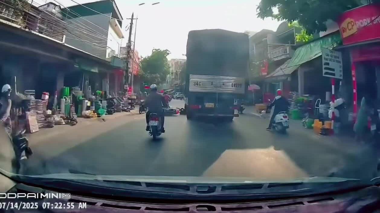 Phanh gấp xe máy, người phụ nữ lăn vào bánh xe tải