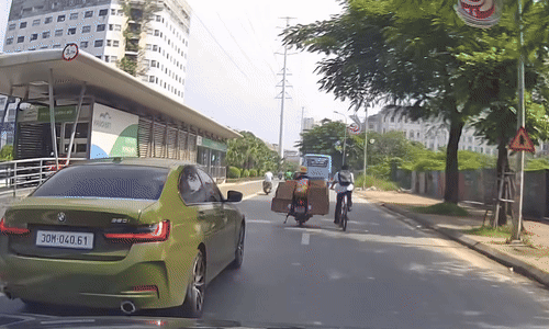 Xe máy huých ngã người đi xe đạp trước đầu ôtô