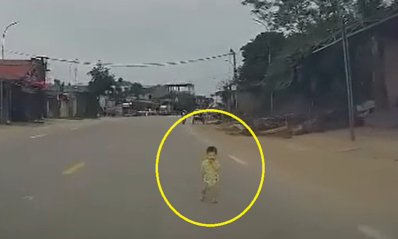 Em bé chập chững lao ra đường trước đầu ôtô
