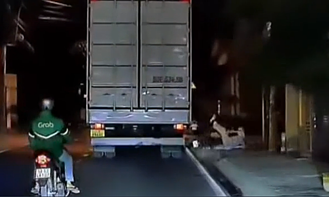 Thanh niên đi xe máy ngã lăn vì cố vượt xe tải