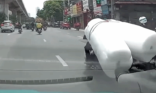 Hàng cồng kềnh đẩy cô gái đi xe máy vào gầm ôtô