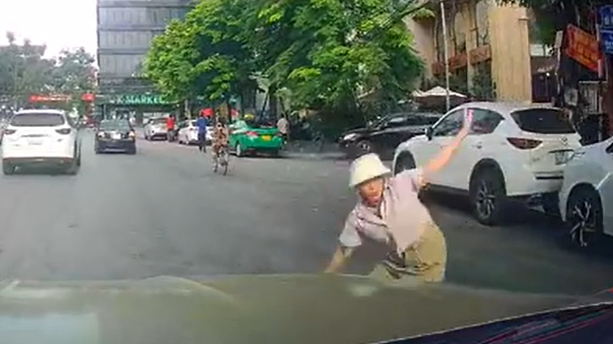 Người phụ nữ lao đầu vào ôtô để nhặt quả xoài rụng